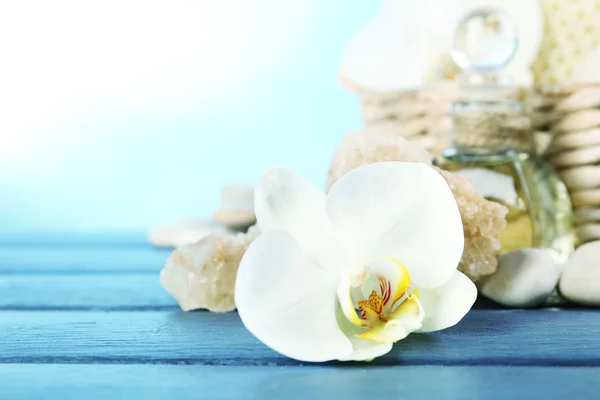 Bodegón con hermosa flor de orquídea en flor, tratamiento de spa en mesa de madera, sobre fondo brillante —  Fotos de Stock