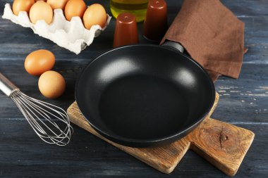 Yumurta ve ahşap arka plan üzerinde tava ile natürmort