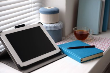 PC tablet, defter ve pencere üzerinde çay. Çalışma yeri kavramı