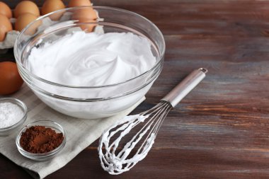 Ahşap arka plan üzerine yumurta akı için krem şanti