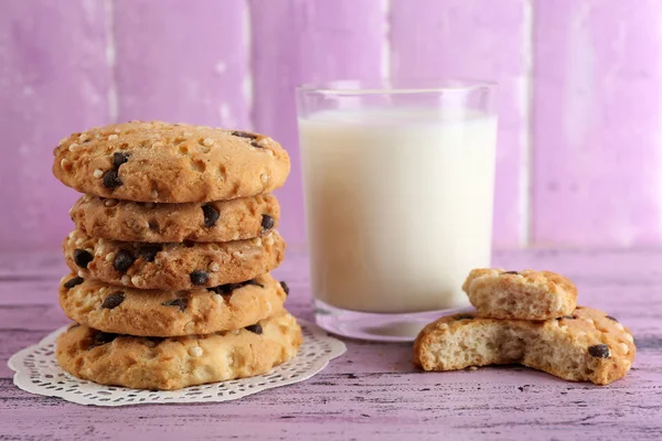 おいしいクッキーとミルク色の木製の背景上のガラス — ストック写真