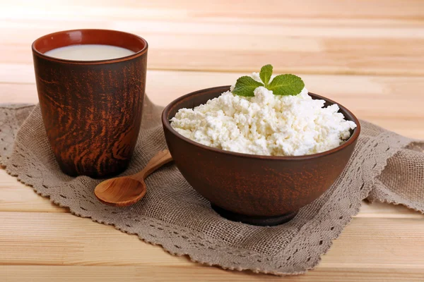 Queso de cabaña en tazón con taza de leche sobre fondo de madera — Foto de Stock