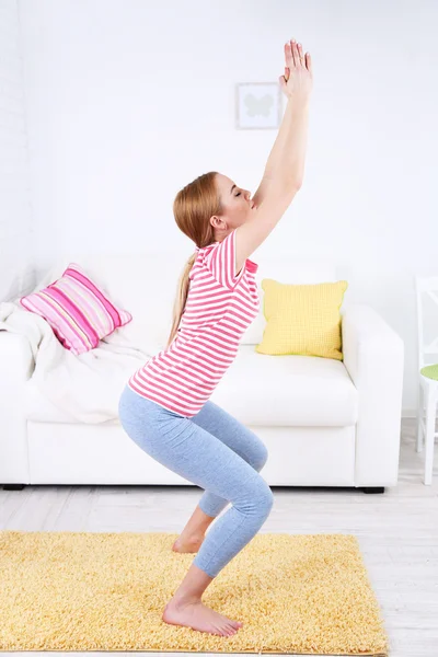 Young woman doing yoga at home — Stock Photo, Image