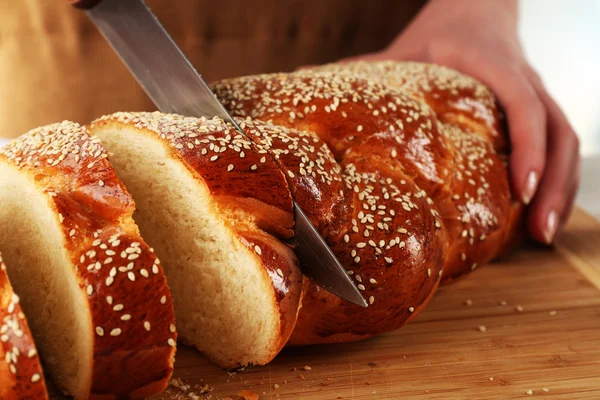 Brötchen schneiden auf Holzbrett auf hellem Hintergrund — Stockfoto