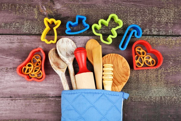 Different kitchen utensils in potholder on wooden background — Stock Photo, Image