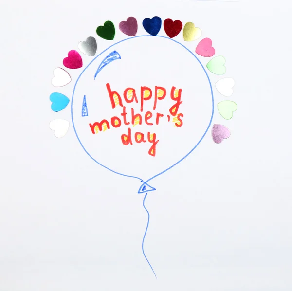 Happy Mothers Day message written on paper with bright hearts close up