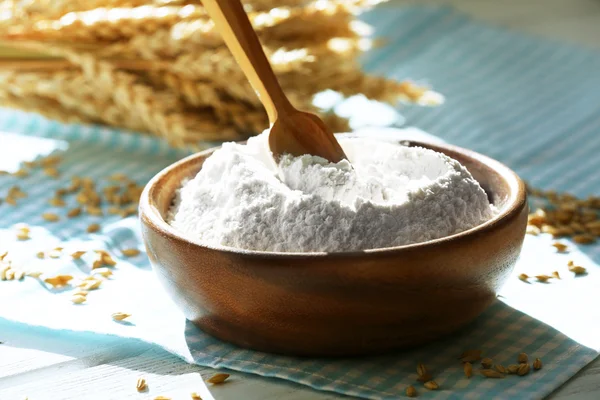 Bowl of flour with spoon and napkin on wooden table, closeup — Stock Photo, Image