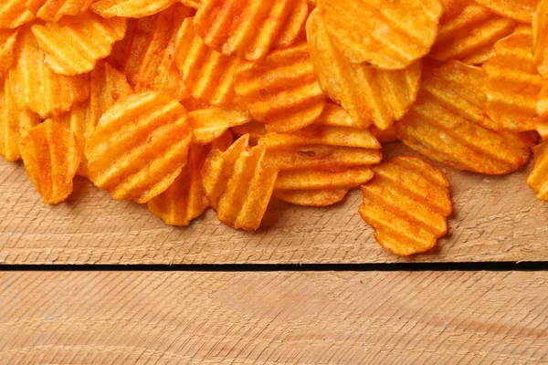 Delicious potato chips on wooden table close-up — Stock Photo, Image