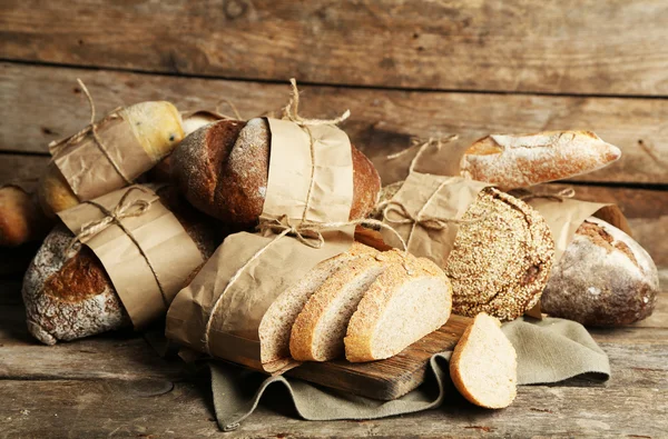 Pane fresco diverso, su vecchio tavolo di legno — Foto Stock