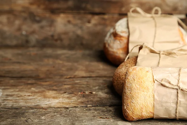 Different fresh bread, on old wooden table — Stock Photo, Image