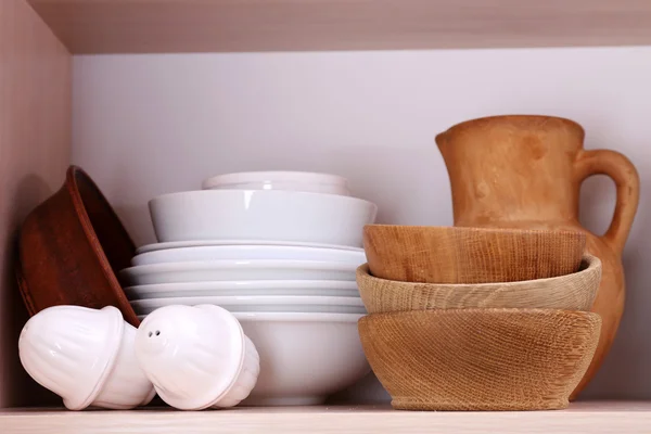 Ustensiles de cuisine et vaisselle sur étagère en bois — Photo