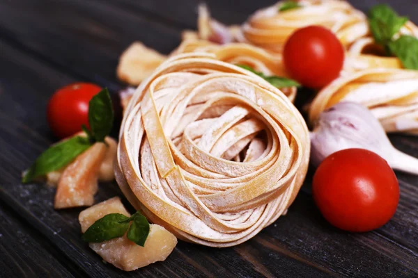 Raw homemade pasta with cheese and vegetables on wooden background — Stock Photo, Image