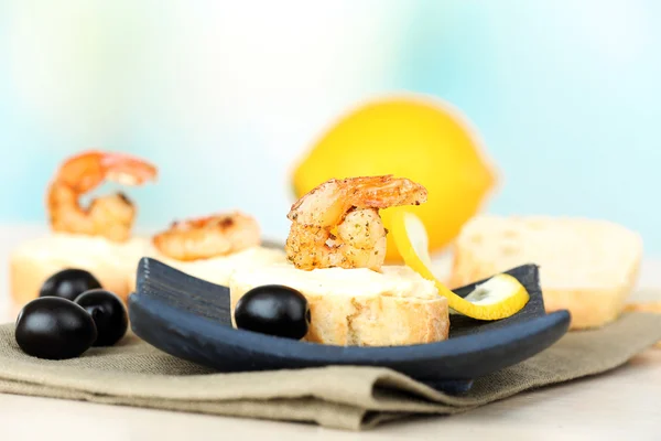 Aperitivo canapé con camarones y aceitunas en la mesa sobre fondo claro — Foto de Stock