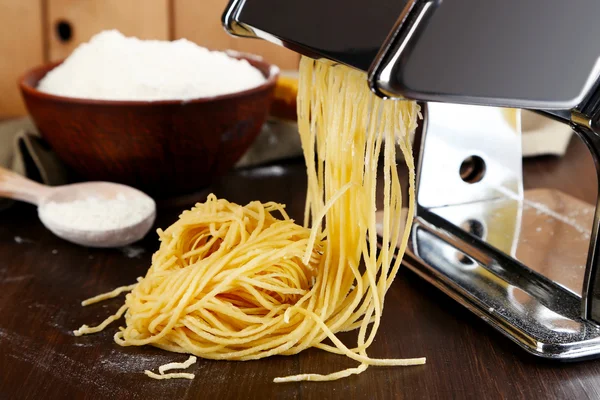 Hacer vermicelli con máquina de pasta sobre fondo de madera — Foto de Stock