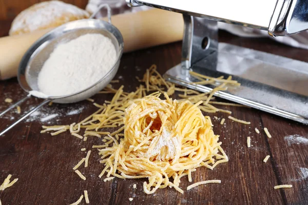 Hacer vermicelli con máquina de pasta sobre fondo de madera —  Fotos de Stock