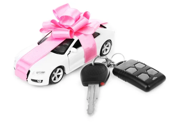 Keys and car with pink bow as present isolated on white — Stock Photo, Image