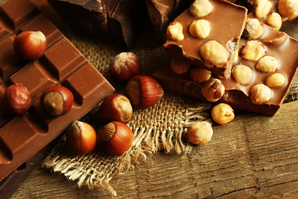 Natureza morta com jogo de chocolate com nozes em mesa de madeira, close-up — Fotografia de Stock