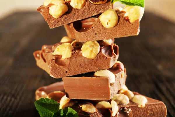 Zásobník čokolády s ořechy na dřevěný stůl, detail — Stock fotografie