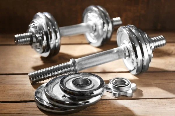 Big dumbbells on wooden background — Stock Photo, Image