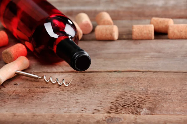 Botella de vino con tapones y sacacorchos sobre fondo de mesa de madera —  Fotos de Stock