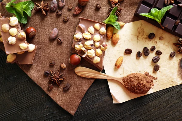 Chocolate with mint, spices and coffee beans on table, closeup