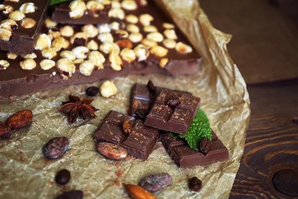 Pyszne czekoladki z przyprawami na stole, zbliżenie — Zdjęcie stockowe