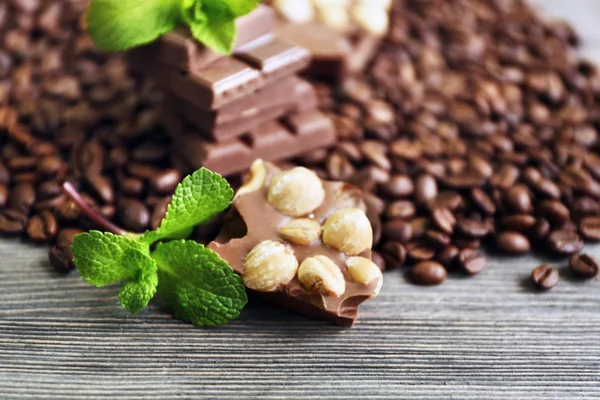 Chocolate with mint and coffee beans on wooden table, closeup — Stock Photo, Image