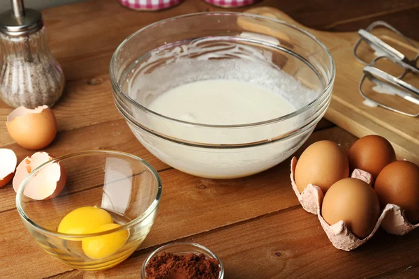 Крем для приготовления яиц в стеклянной чаше на деревянном фоне — стоковое фото