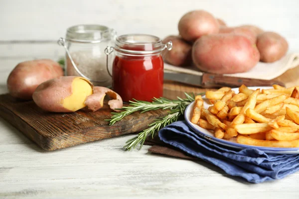 Välsmakande pommes frites på plattan, på träbord bakgrund — Stockfoto