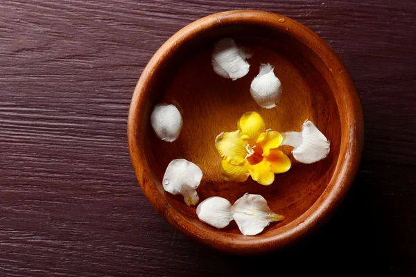 Pétalos de flores en cuenco, primer plano, sobre fondo de mesa de madera — Foto de Stock