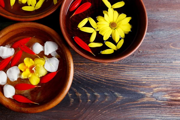 Pétalas de flores em taças, close-up, sobre fundo de mesa de madeira — Fotografia de Stock