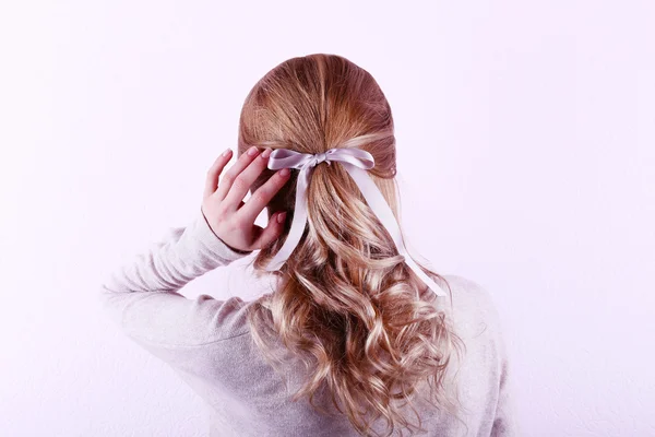 Peinado femenino con cinta de color sobre fondo de pared blanco — Foto de Stock