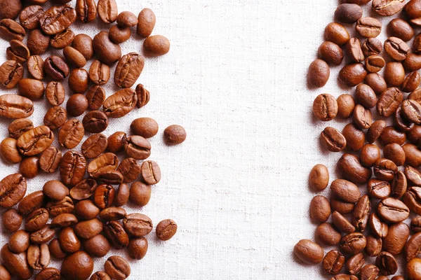Quadro de grãos de café em fundo de pano de saco de cor — Fotografia de Stock