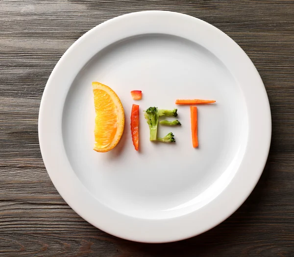 Word dieet gemaakt van gesneden groenten in plaat op houten tafel, bovenaanzicht — Stockfoto