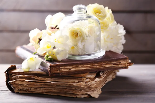 Hermosa composición con flores y libros antiguos sobre fondo de madera gris — Foto de Stock