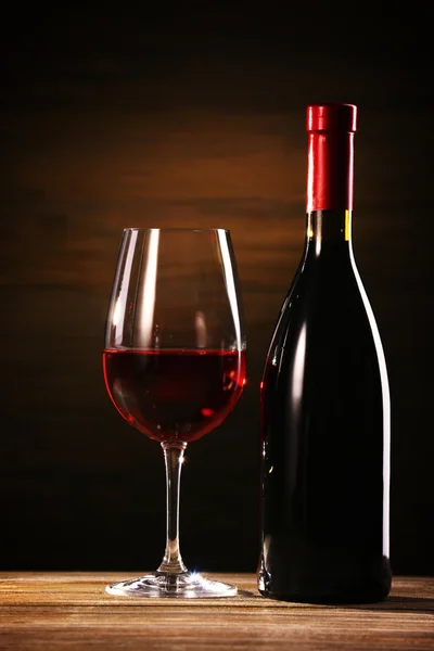 Bicchiere da vino e bottiglia su sfondo di legno — Foto Stock
