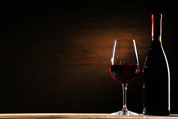 Wineglass και μπουκάλι σε ξύλινα φόντο — Φωτογραφία Αρχείου