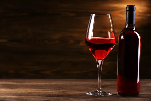 Wineglass και μπουκάλι σε ξύλινα φόντο — Φωτογραφία Αρχείου