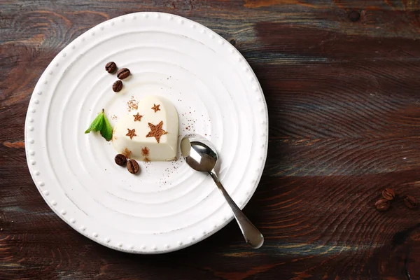 Sabroso panna cotta postre en plato, sobre mesa de madera — Foto de Stock