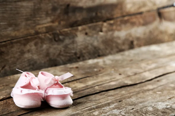 Sapatos de criança rosa no fundo de madeira — Fotografia de Stock