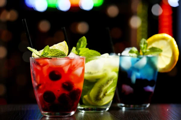 Окуляри коктейлів у барі на яскравому розмитому фоні — стокове фото