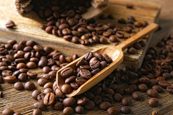 Grãos de café na mesa de madeira, close-up — Fotografia de Stock