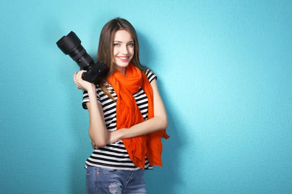 Jonge vrouwelijke fotograaf foto's nemen op blauwe achtergrond — Stockfoto