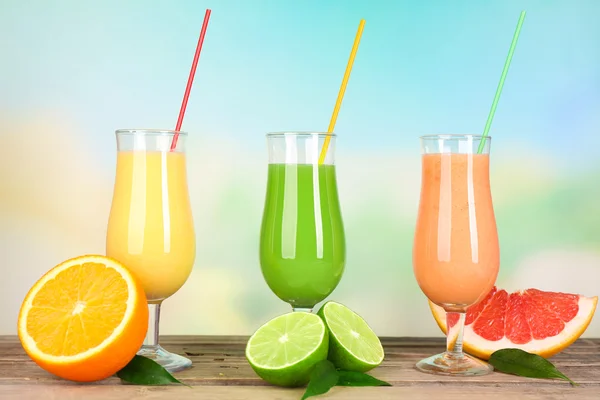 Fresh summer cocktails with fruits on wooden table on bright blurred background — Stock Photo, Image
