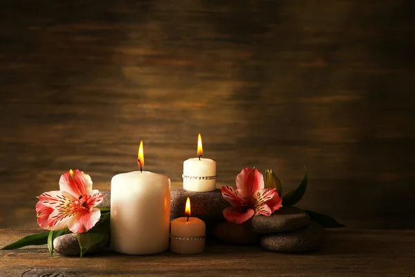 Hermosa composición con velas y piedras de spa sobre fondo de madera — Foto de Stock