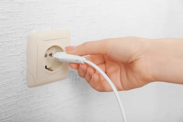 Mão colocando plug-in tomada de eletricidade de perto — Fotografia de Stock