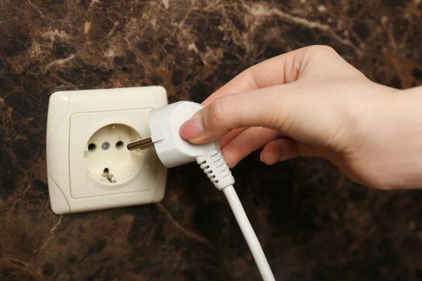 Hand putting plug in electricity socket close up — Stock Photo, Image