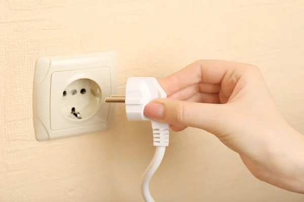 Mão colocando plug-in tomada de eletricidade de perto — Fotografia de Stock