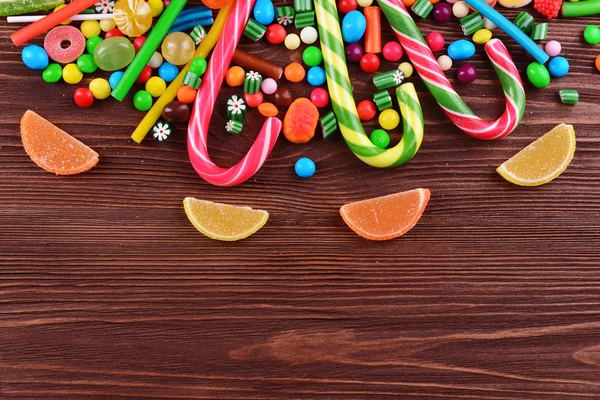 Doces coloridos em fundo de madeira — Fotografia de Stock