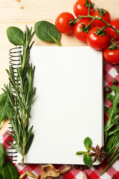 Open recipe book with fresh herbs